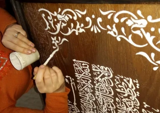 Aliya Alnuami is applying the relief paste on her ‘Ajami-work