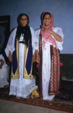 Two Kurdish women. The woman on the right is wearing a traditional woven overgarment