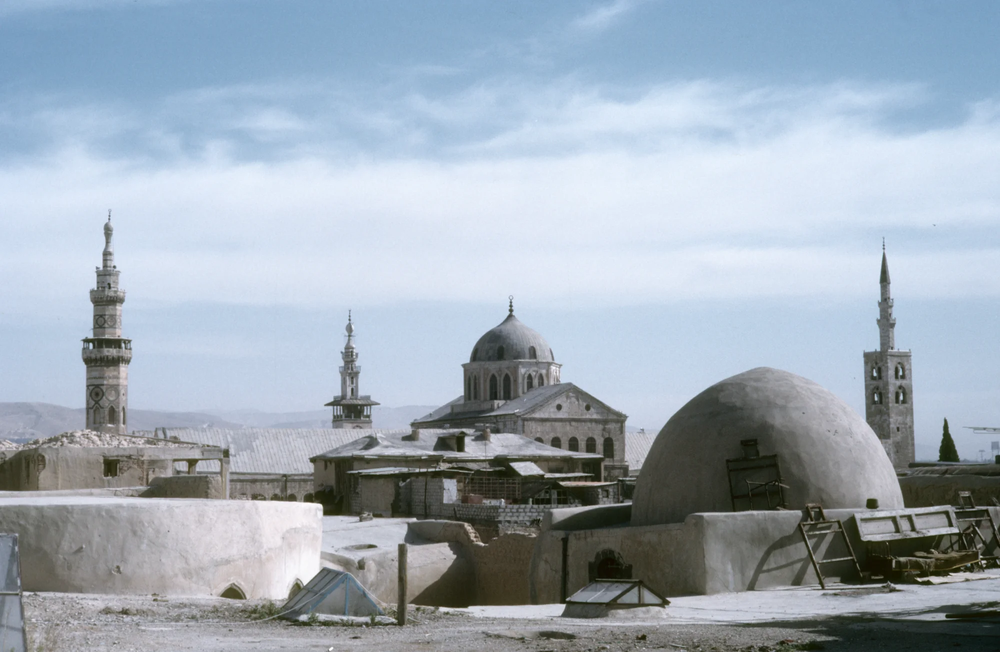 View over the roof of the south-western Madrasat Ismaʿil Basha al-ʿAzm to the Umayyad Mosque with its high transept of the prayer hall with a central dome and its three minarets
