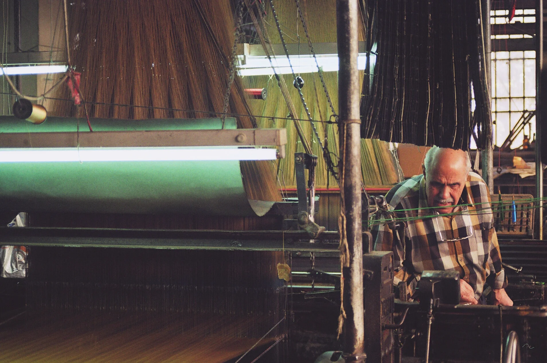 A craftsman working on a Jacquard loom in the textile factory of the Mezannar family, Damascus